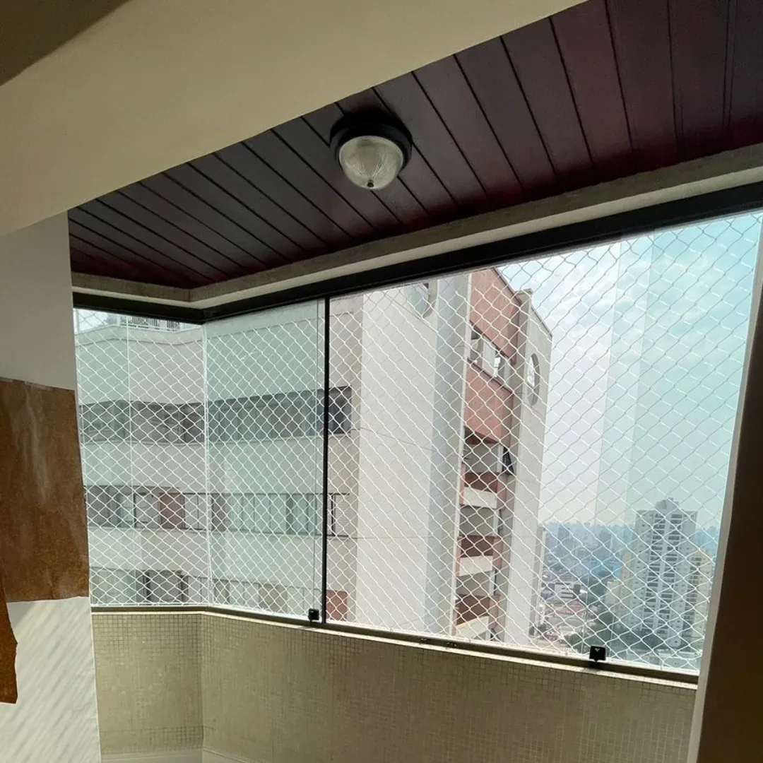 Sacada envidraçada com rede de proteção