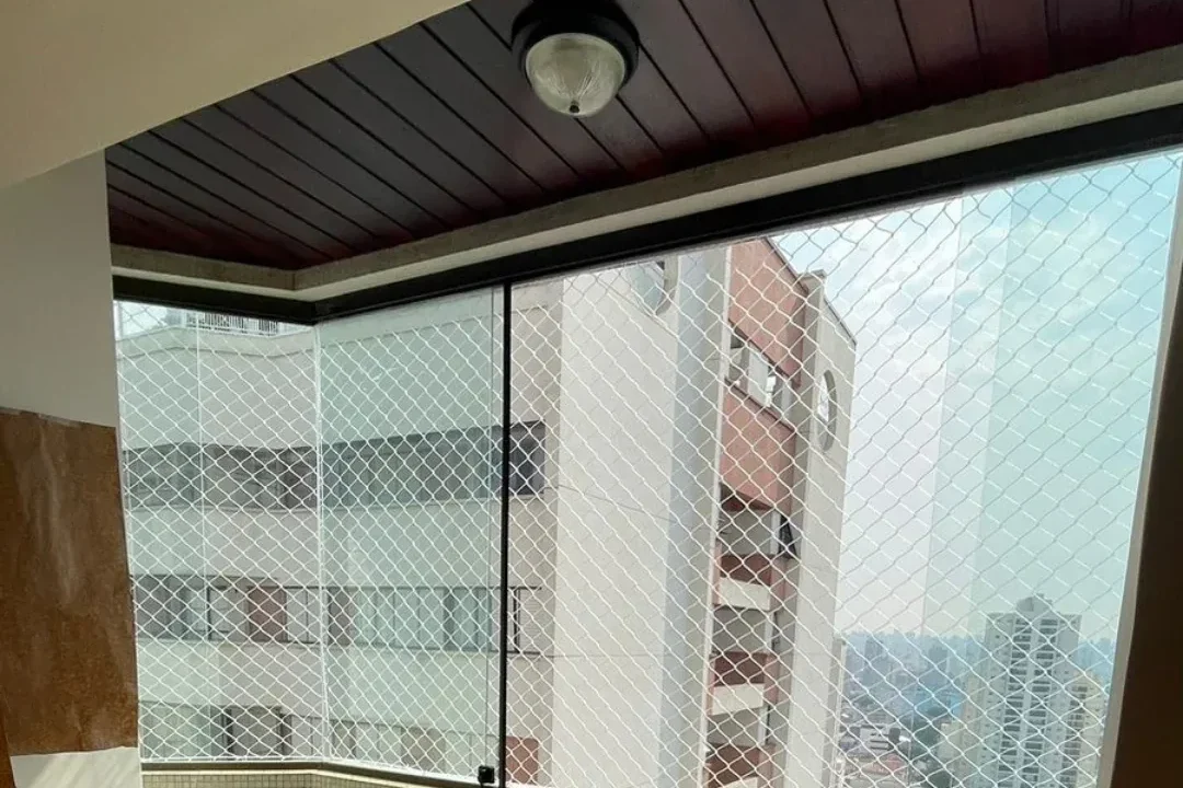 Sacada envidraçada com tela de proteção instalada em apartamento de São Paulo